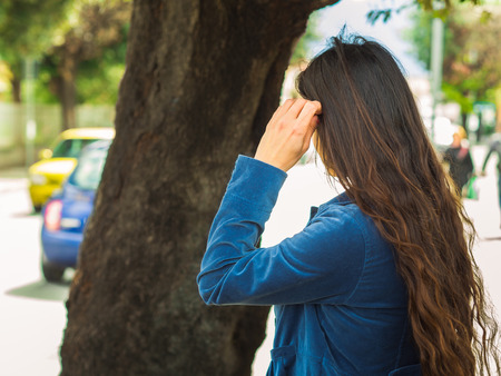Authentic young woman outdoors turned with her back. Urban sceneの写真素材