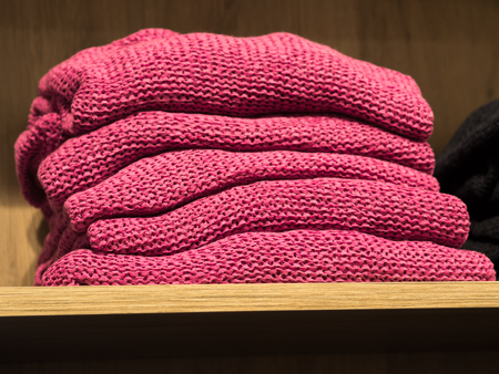 Pile of pink coral sweaters in a womans fast fashion storeの写真素材