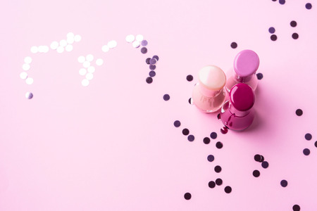 Pink nail polishes with confetti heart. Copy space. Flat layの写真素材