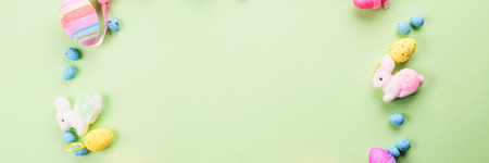 Easter colorful decor flat lay frame on green pastel background. Spring colors