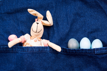 Easter boiled eggs and bunny in jeans apron pocket. Holiday concept flat layの写真素材
