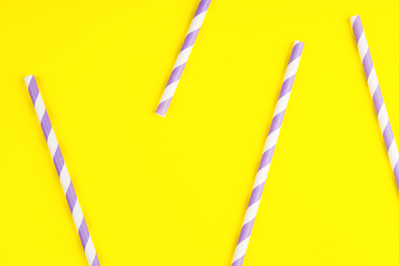 Purple paper straws on bright yellow color background. Patternの写真素材