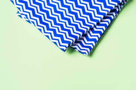 Blue geometrical napkin on pastel green background. Cooking conceptの写真素材