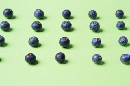 Pattern of fresh blueberries in on pastel green background. Healthy breakfast conceptの写真素材