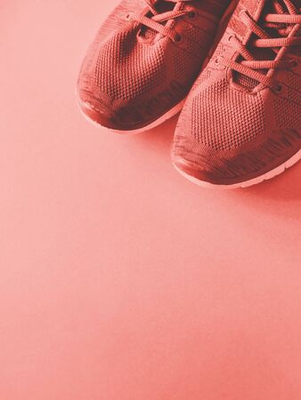 Sports trainers on empty background. Coral pink toneの写真素材