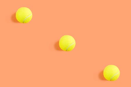 Tennis ball pattern on orange coral abstract background. Game, practise, competition concept. Trendy...