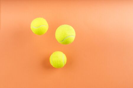 Tennis balls bouncing on orange abstract background. Competition concept