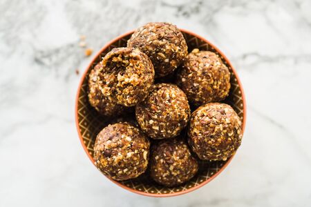 Energy protein balls with healthy ingredients on marble table. Home made with dates, peanut butter,...