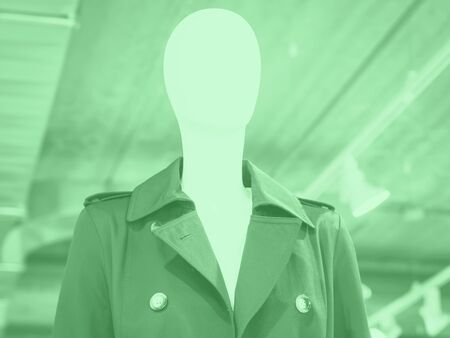 White mannequin wearing blue trench in a fast fashion store. Mint green color of 2020の写真素材