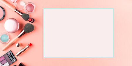 Make up products and brushes on pink background. Beauty items colorful fashion flat lay banner with pink card for textの写真素材