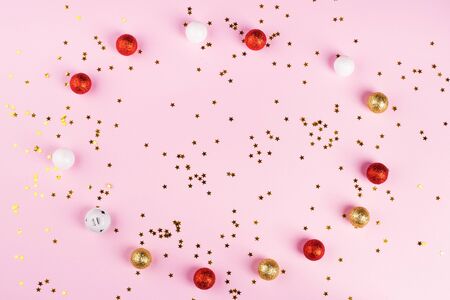 Christmas ornament bauble flat lay circle frame on pink. Golden star confettiの写真素材