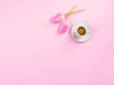 Cup of coffee and tulips on millennial pink background. Concept banner for mothers day, valentines day, good morning flat layの写真素材