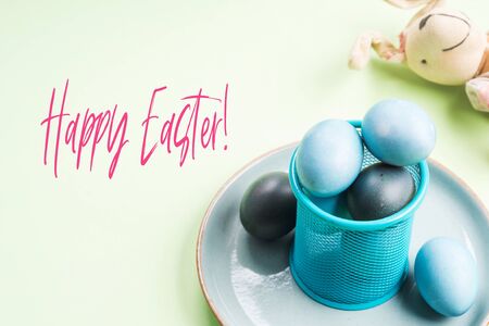 Blue easter eggs on pastel green background. Festive symbol stille life greeting card with Happy...