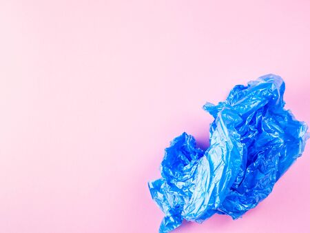 Crumpled blue plastic trash bag on pink background. Recycling, going plastic free conceptの写真素材