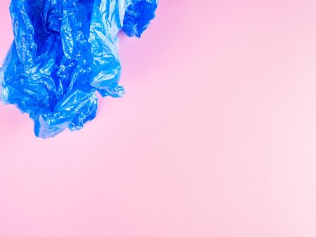 Crumpled blue plastic trash bag on pink background. Recycling, going plastic free conceptの写真素材