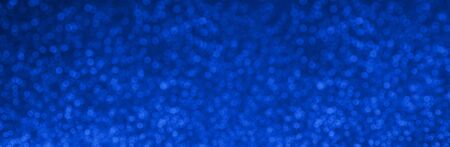 Festive classic blue color of 2020 year metallic glitter abstract background with bokeh lights