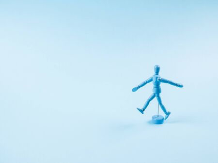 Blue wooden human marionette dummy walking alone on monochrome backdropの写真素材