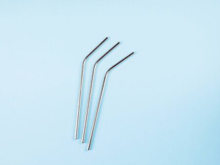 Eco friendlyplastic free stainless steel reusable drinking straws on blue pastel background. Flat...