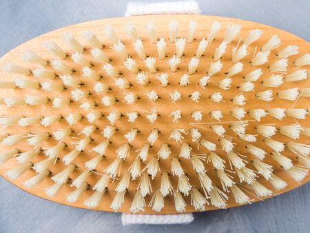 Wooden dry massage brush on blue background. Healthy lifestyle. Zero waste