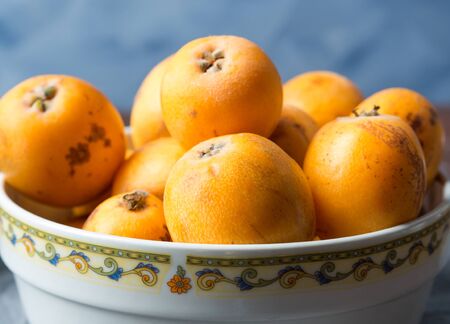 Loquat Japanese medlar fruit in bowl on dark backgroundの写真素材