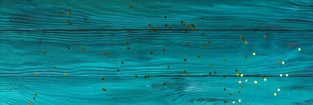 Dark green wooden background web banner with golden festive star shaped confettiの写真素材