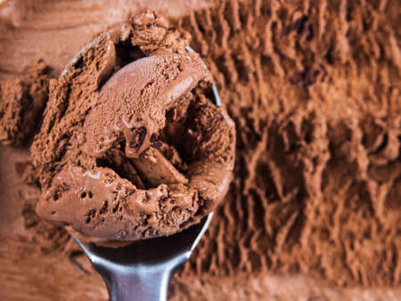 Full ice cream scoop in chocolate ice cream tub. Macro texture