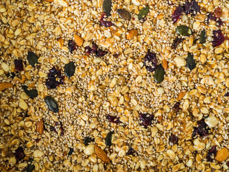 Home made energy granola with nuts, dried fruit, peanut butter and superfoods baked in baking tin to be cut in granola bars healthy snack. Closeup texture backgroundの写真素材