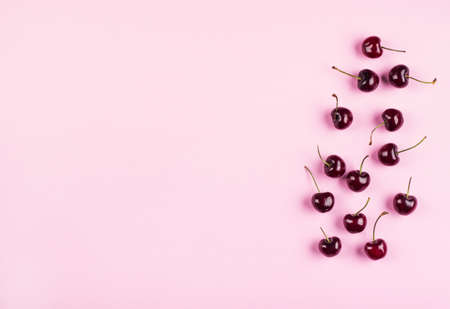 Heap of cherries on pink background. Flat lay, copy spaceの写真素材