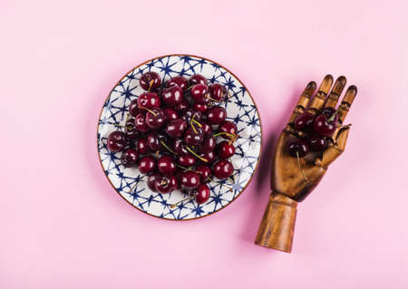 Heap of cherries on ceramic dish on pink background. Hello summer conceptの写真素材