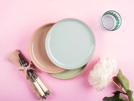 Pastel color crockery tableware on pink background. Textured empty ceramic dishes. Table setting...