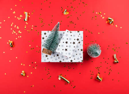 Christmas new year red festive background with toy xmas treesand white gift boxes