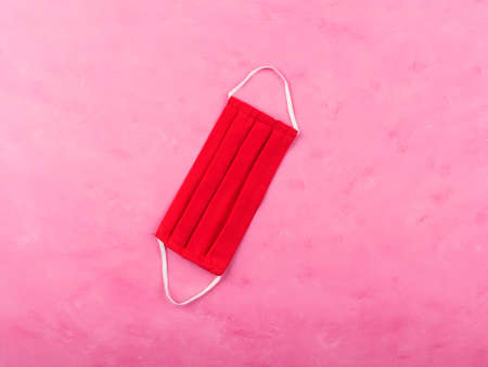 Hand made red cotton face mask protection on pink background. New normal fashion in times of Coronavirus Covid-19の写真素材