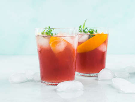 Fresh red cocktail mocktail sangria in glasses with ice, mint leaves and lemon and orange slices on...