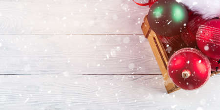 Christmas red and green decor in wooden box on white wooden table. Seasonal festive greeting cardの写真素材