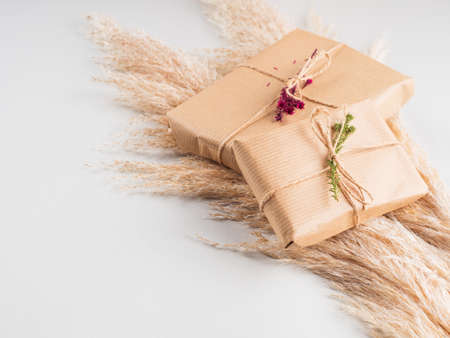 Zero waste holiday gifts wrapped in plastic free paper with dried floral decor on gray background.の写真素材