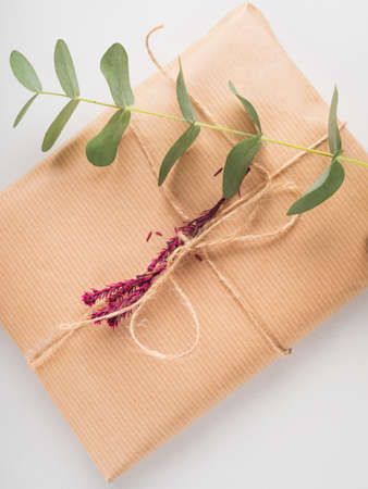 Zero waste holiday gifts wrapped in plastic free paper with dried floral decor on gray background.の写真素材