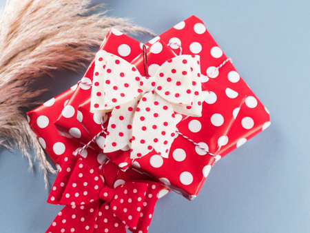 Vintage style gifts stack wrapped in polka dot paper with bows on blue background. Christmas,...