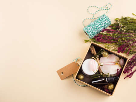 Zero waste beauty christmas new year gift box with flowers. Guasha, essential oil, bamboo toothbrushes, cotton pads, cream.の写真素材