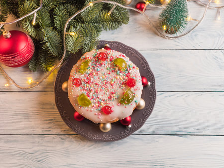 Sweet christmas cake with xmas holiday decor and lights. Traditional italian sweet casatiello bread with frosting and candied fruitの写真素材