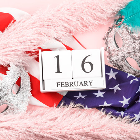 2021 Mardi Gras masks on american flag, February, 16 date on wooden calendar and pampas grass on pink background. Squareの写真素材