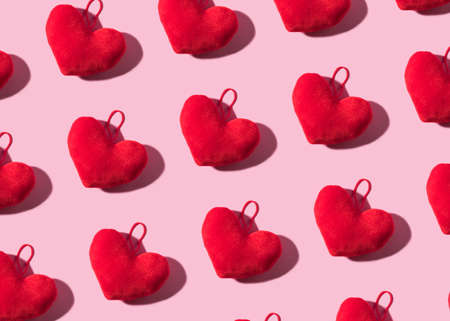 Trendy Valentines day backgound with stuffed red heart and hard shadow on pink. Love symbol conceptの写真素材