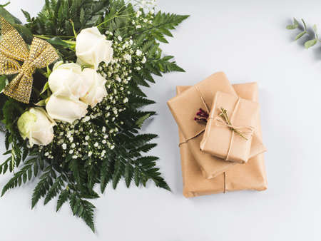 Beautiful bouquet of white roses and wrapped gift boxes for anniversary, birthday, womens, mothers, valentine day. Floral designの写真素材