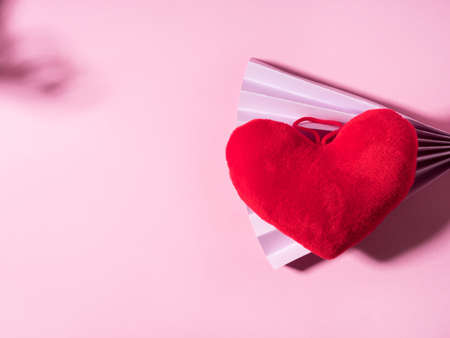Trendy Valentines day backgound with stuffed red heart and purple paper fan on pink. Love conceptの写真素材