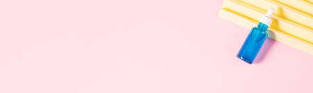 Hyaluronic acid serum generic bottle treatment on pink geometric background with yellow paper fan
