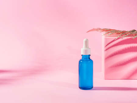 Hyaluronic acid serum generic bottle treatment on pink geometric background with shadowsの写真素材