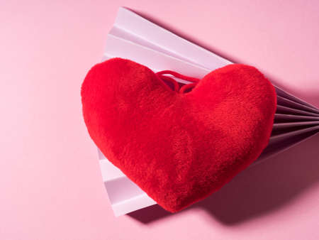 Trendy Valentines day backgound with stuffed red heart and purple paper fan on pink. Love conceptの写真素材