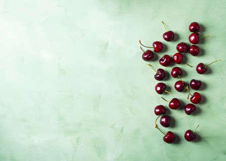 Fresh summer cherries berries on green background. Copy space.