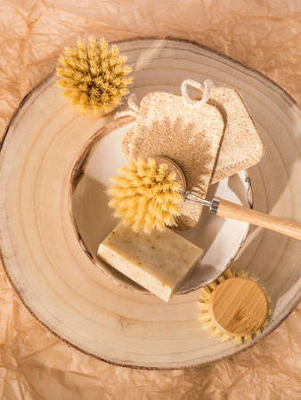 Zero waste natural dish washing kitchen home eco cleaning products - wooden brushes, loofah sponge, bio soap bar on neutral beige backgroundの写真素材