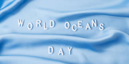World oceans day in white letters on blue wave textile, june 8 holiday