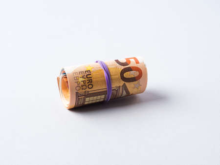 Euro 50 value banknotes roll with rubber on gray background